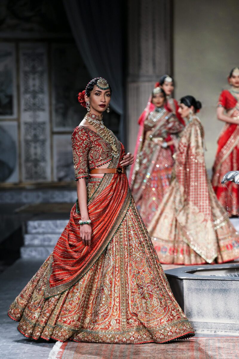Models showcase intricate traditional Indian outfits on a runway in New Delhi.