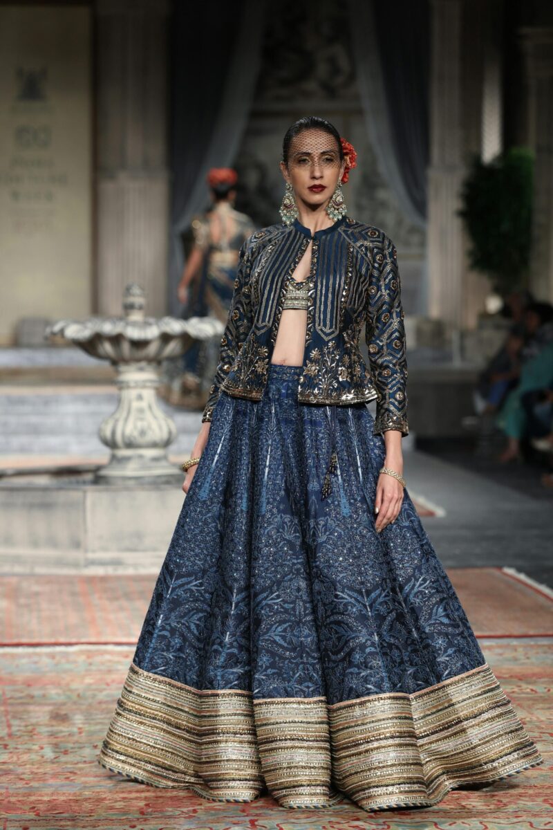 Indian model showcases traditional blue attire at a New Delhi fashion show.