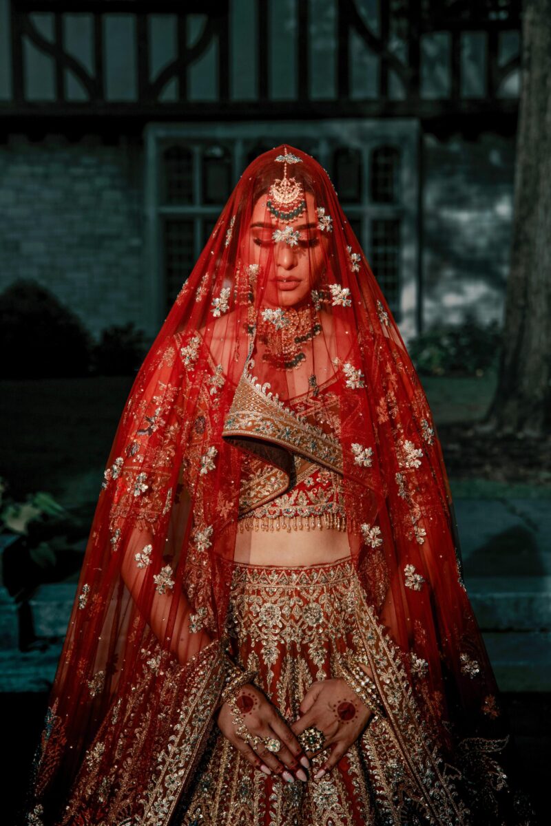Stunning Indian bride in intricate red lehenga and jewelry, capturing cultural elegance.